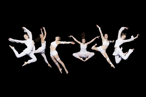 Sechs weiß gekleidete Tänzerinnen springen vor einem schwarzen Hintergrund in die Luft. © Company_Foto: Nele Schechowsky.jpg