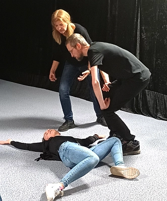 Eine Schauspielerin liegt auf dem Boden, zwei anderen Schauspielende beugen sich über sie.&nbsp;&copy;&nbsp;Ri