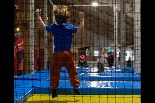 Kind von hinten in einer Trampolinhalle