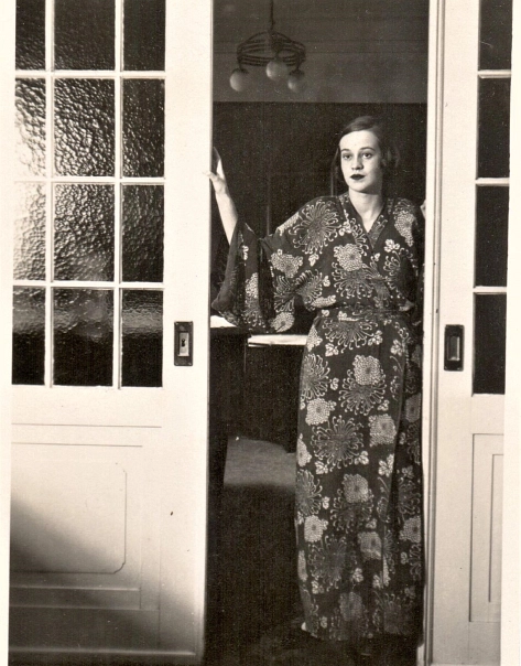 Eine Frau in Kittelschürze steht in einer Tür. © DIE KITTELSCHÜRZE_Foto: Ä. Beineberg